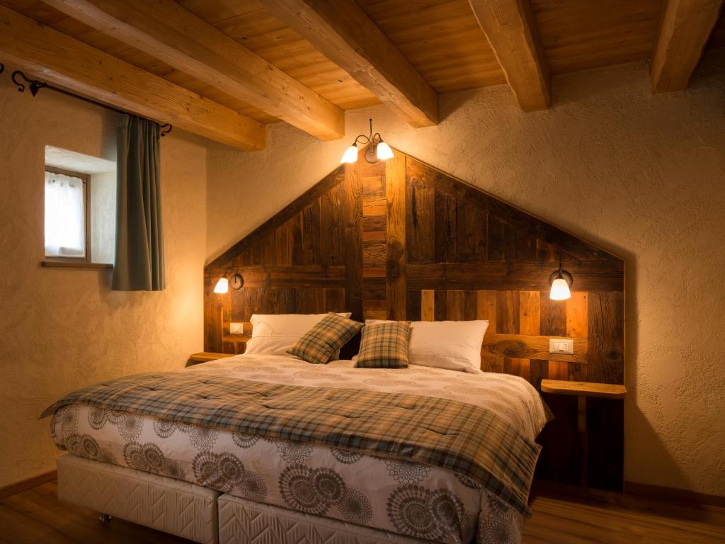 奥斯塔Chambres d'hôtes La Moraine Enchantée的一间卧室设有一张带木墙的大床