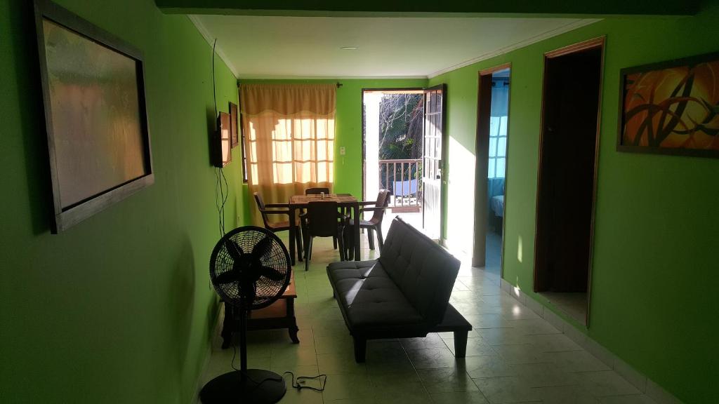 圣安德烈斯Miss Leila的客厅设有绿色的墙壁、椅子和桌子