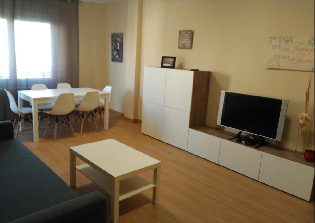 萨莫拉Zamora Apartments的客厅配有电视和桌椅