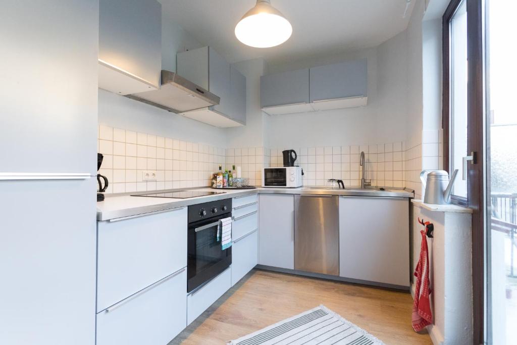 不莱梅Apartementhaus Gneisenaustraße的白色的厨房设有水槽和炉灶。