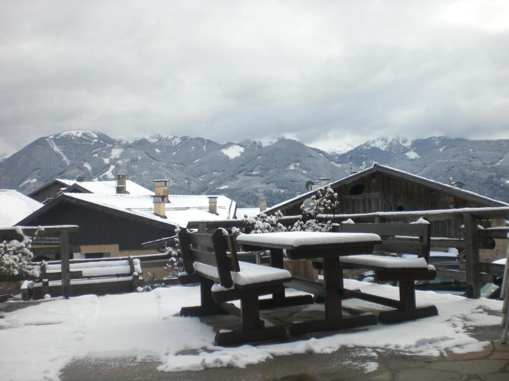 瓦雷纳Albergo Pensione Serenetta的山景雪盖野餐桌