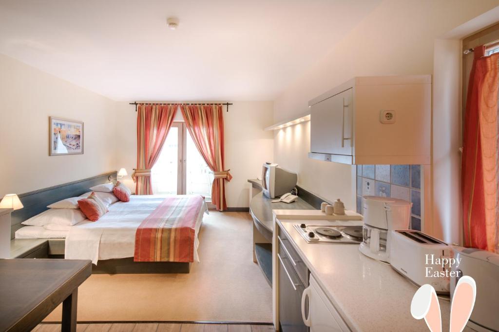 赫维兹Hotel Kalma的酒店客房带一张床和一个厨房