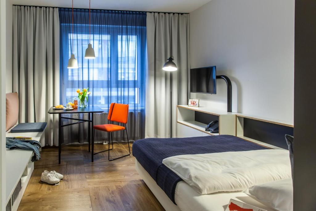 维也纳SMARTments business Wien Hauptbahnhof - Serviced Apartments的配有一张床、一张桌子和一张桌子的酒店客房