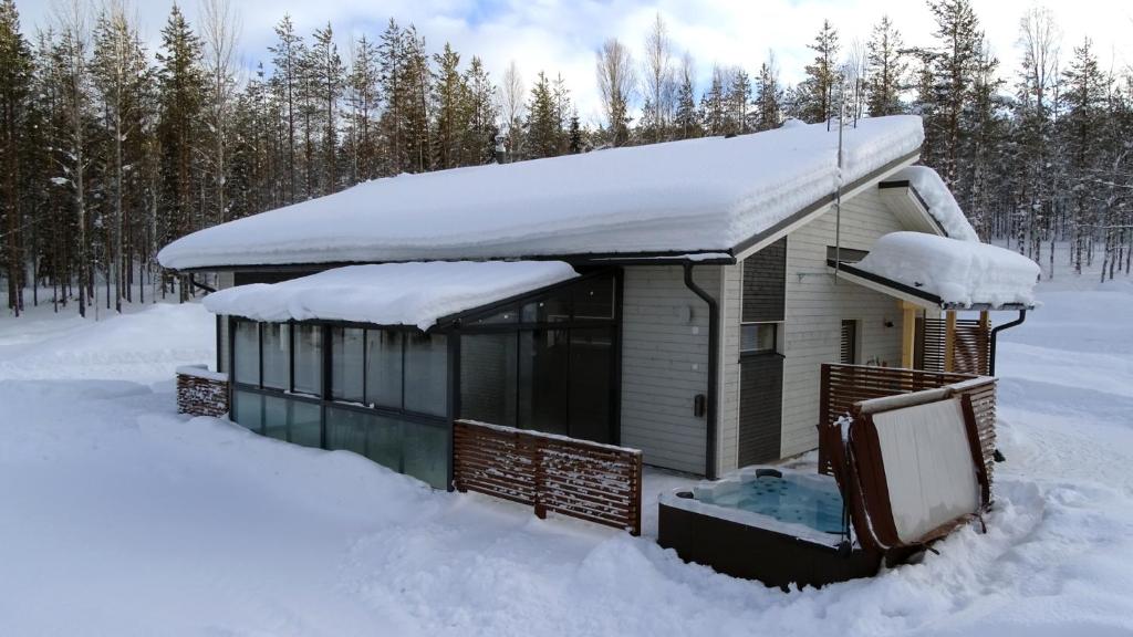 SonkaLumikko Villa的树林里积雪覆盖的房子