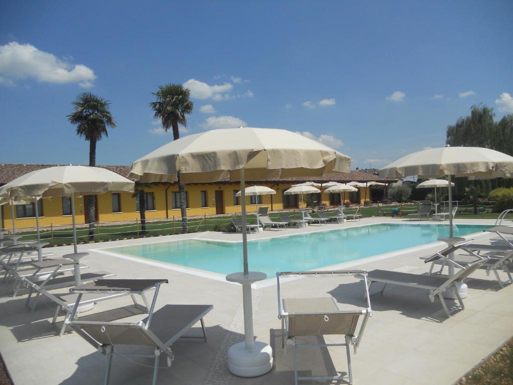 多索博诺里卡希迪康帕尼亚农庄酒店的大楼前的带椅子和遮阳伞的游泳池