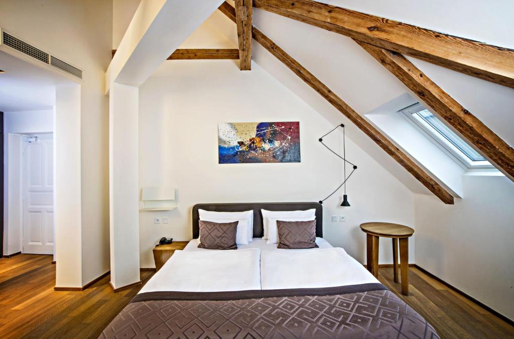 布拉格金冠酒店的阁楼上的卧室配有一张大床