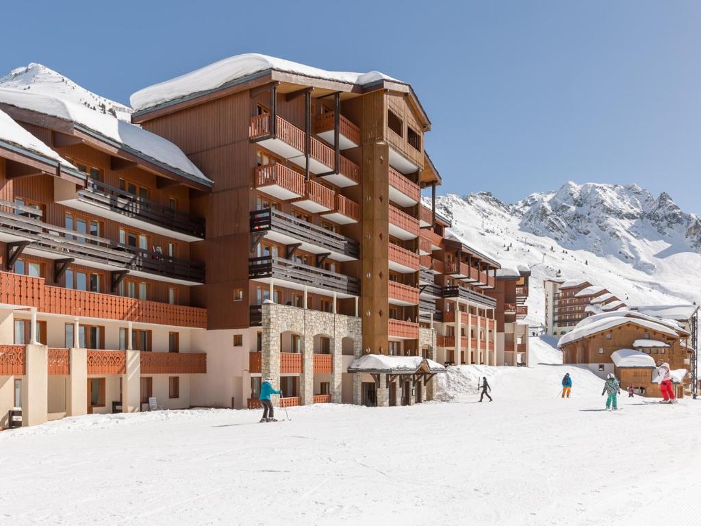 贝勒普拉涅Residence Les Constellations - maeva Home的一群人在滑雪小屋前滑雪