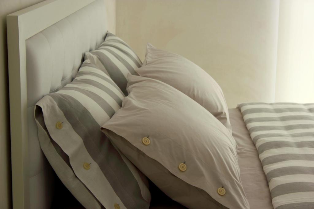 米兰米兰住宿加早餐旅馆的房间里的床上有一堆枕头