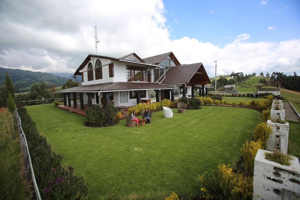 卡扬贝Hosteria Loma Larga Cayambe的前面有大草坪的房子