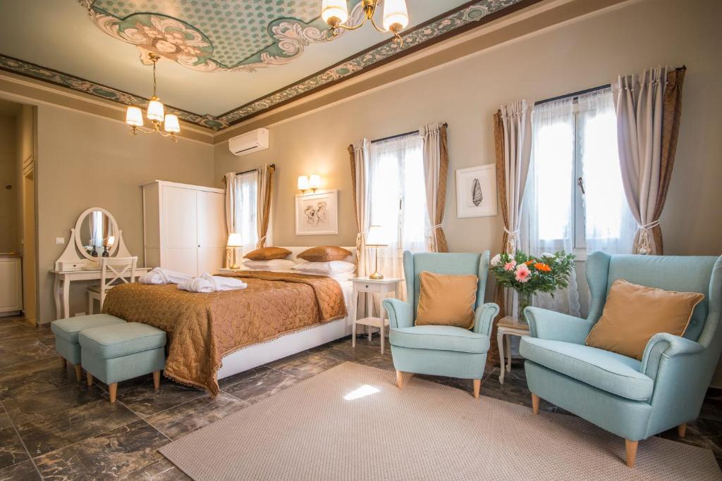 锡米Symi Nautilus Luxury Suites的一间卧室配有一张床和两张蓝色椅子