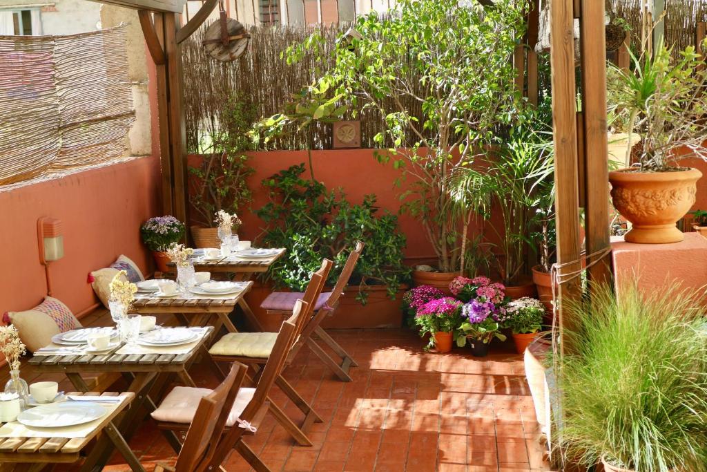 巴塞罗那Hostal Poblenou的一个带桌椅和植物的庭院