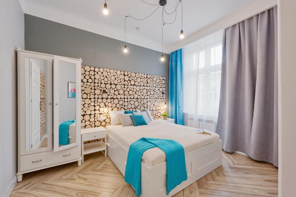 克拉科夫Scandic Apartments - Old Town的卧室配有白色的蓝色调床。