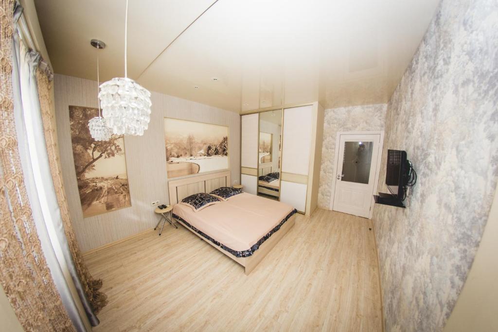 沃罗涅什ATLANT Apartments 109的一间卧室配有一张床和一个吊灯
