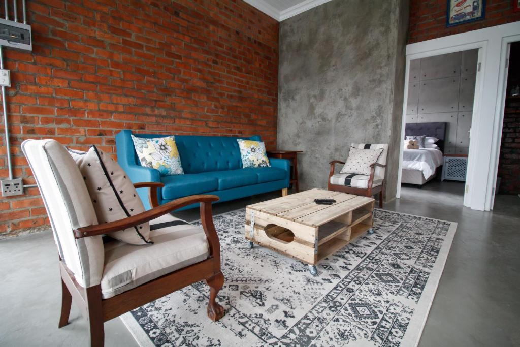 德班维尔Rustic Retreat Apartment in Durbanville的客厅配有蓝色的沙发和茶几