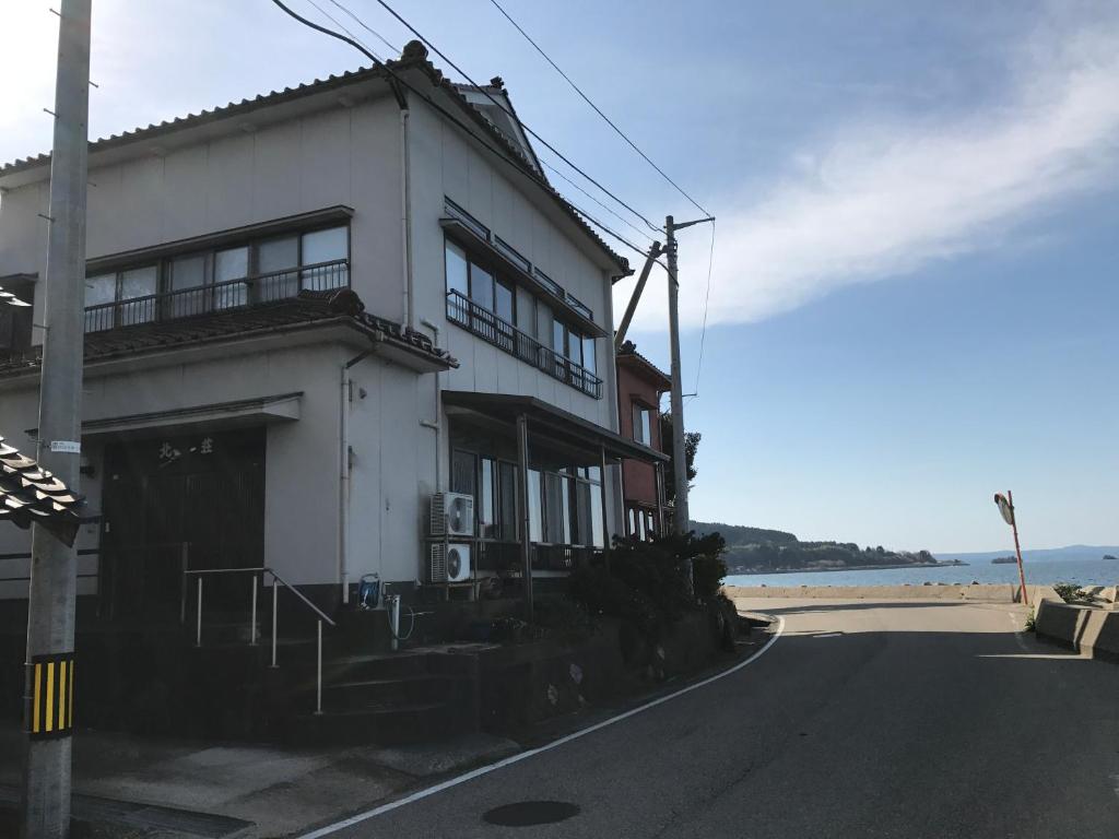 七尾Notojima Guesthouse HaNaMi的海滩边的白色建筑