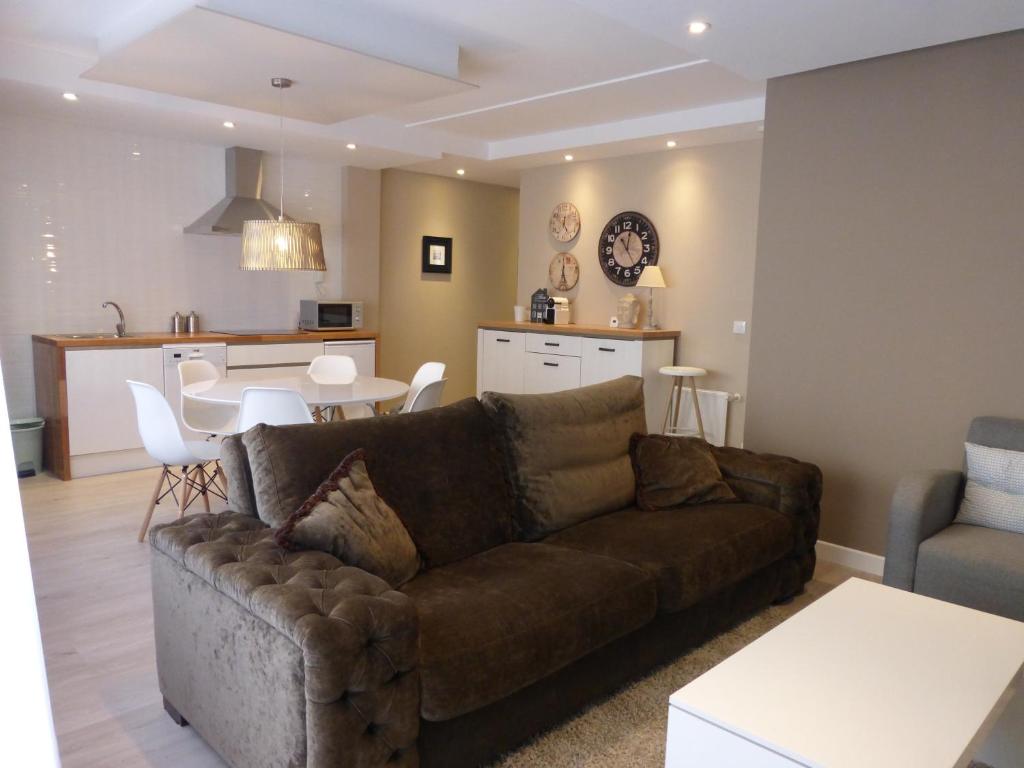 里瓦德奥Apartamento centro Ribadeo的一间带棕色沙发的客厅和一间厨房