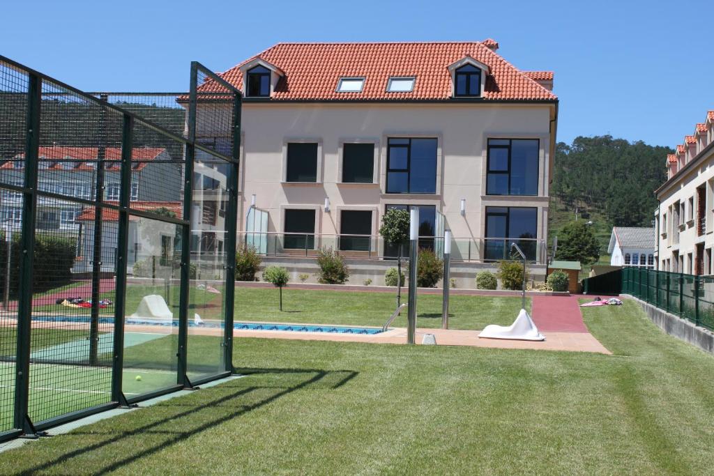 福斯特拉Grupoele3 Edificio Mar Langosteira的享有带网球场的房子的景色