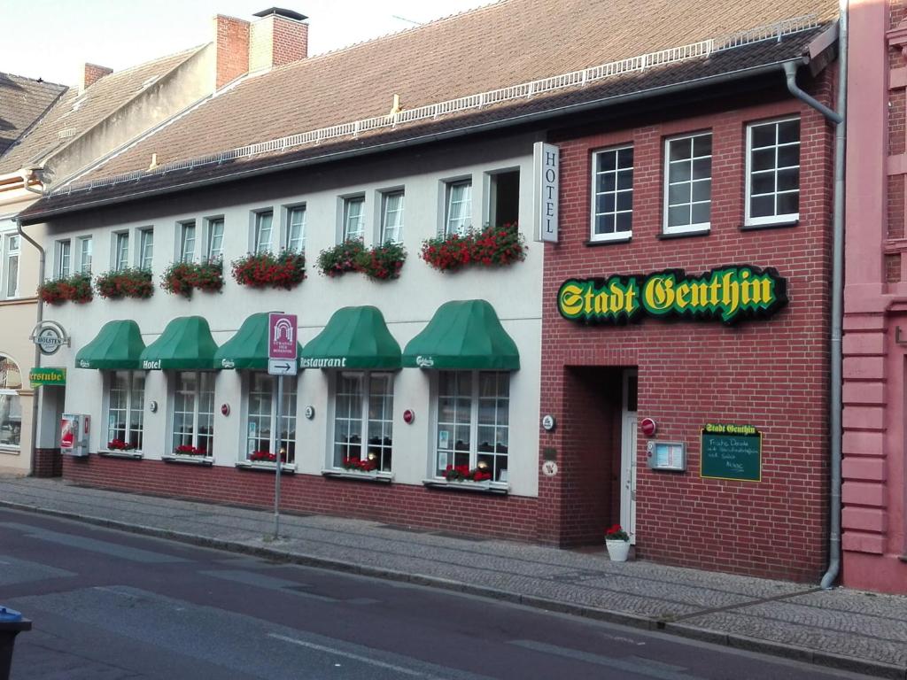 根廷Hotel & Restaurant Stadt Genthin的街道上带有绿色遮阳篷的砖砌建筑