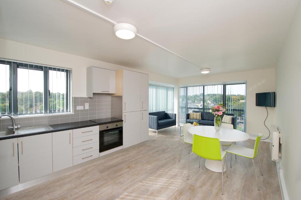 科克University Hall Apartments - UCC Summer Beds的厨房配有白色橱柜、桌子和用餐室。