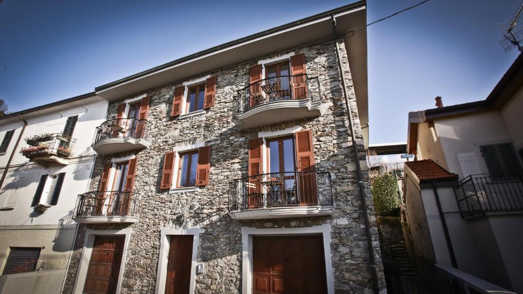 下麦克加诺Casa della Vittoria的一座古老的石头建筑,设有窗户和阳台