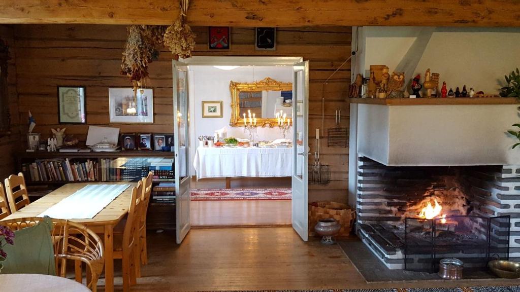 凯里迈基Lomatila Ollila Farm Stay的带壁炉的客房和带桌子的用餐室