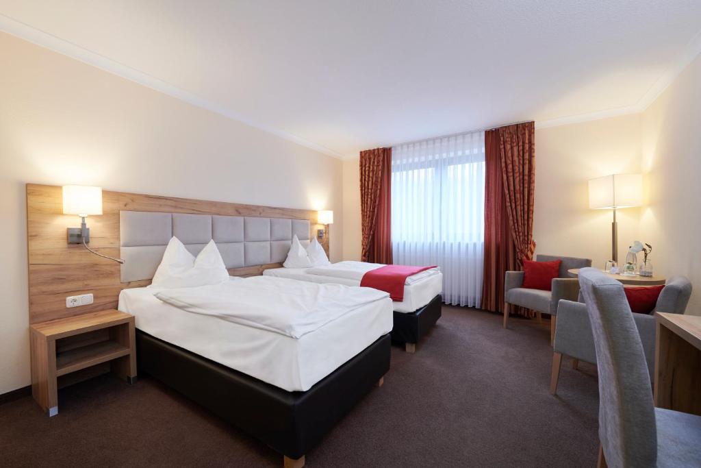 利希滕费尔斯克朗可柏城市酒店的酒店客房,配有两张床和椅子