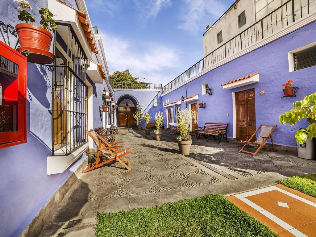 阿雷基帕拉斯托雷斯乌加特酒店的蓝色建筑的庭院,配有桌椅