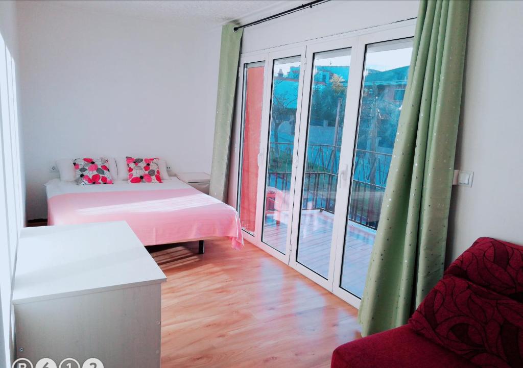 特拉萨拉卡萨公寓的客房设有一张床和带阳台的窗户。