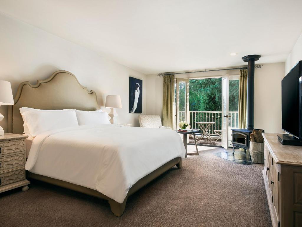 米尔谷米尔谷旅馆的一间带一张白色大床的卧室和一个阳台