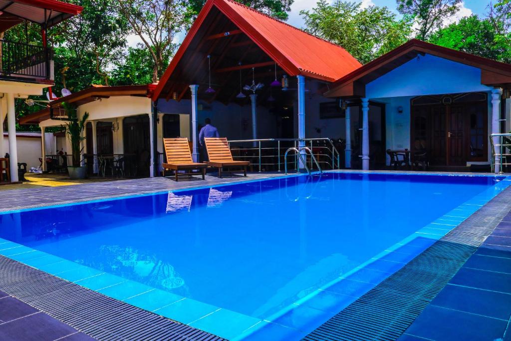 丹不拉西恩富度假村的一座大蓝色游泳池,位于房子前
