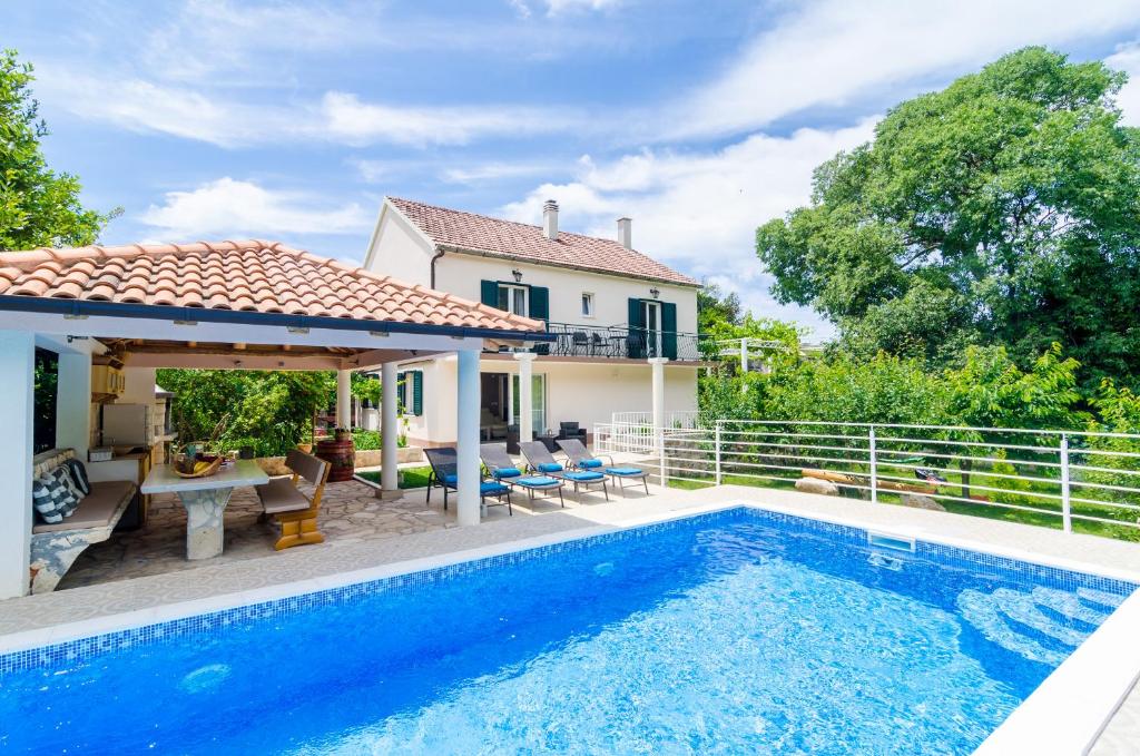 格鲁达Beautiful Countryside Villa的一座带游泳池和房子的别墅