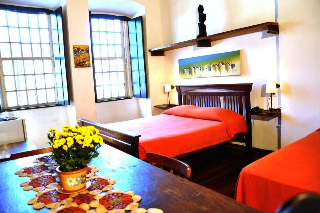 萨尔瓦多卡尔穆精品一室公寓酒店的配有床和鲜花桌的酒店客房