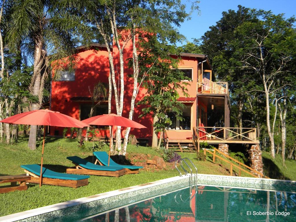 埃尔索韦维奥埃尔索韦维奥山林小屋的游泳池旁带遮阳伞和椅子的房子