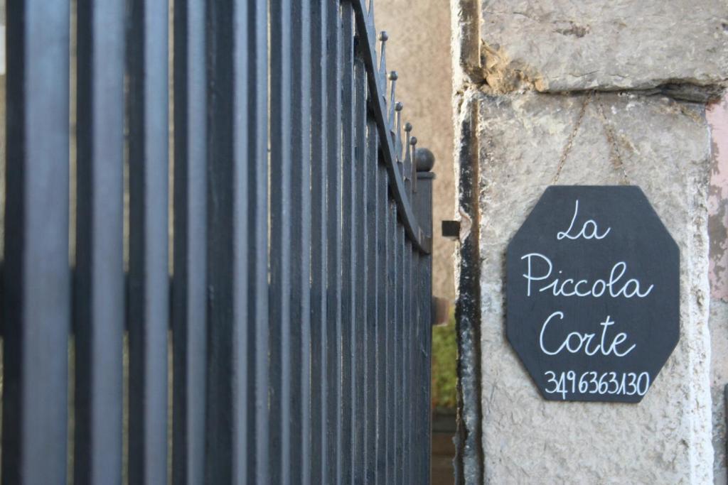 波尔佩纳泽德尔加尔达B&B La Piccola Corte的金属栅栏边的标志