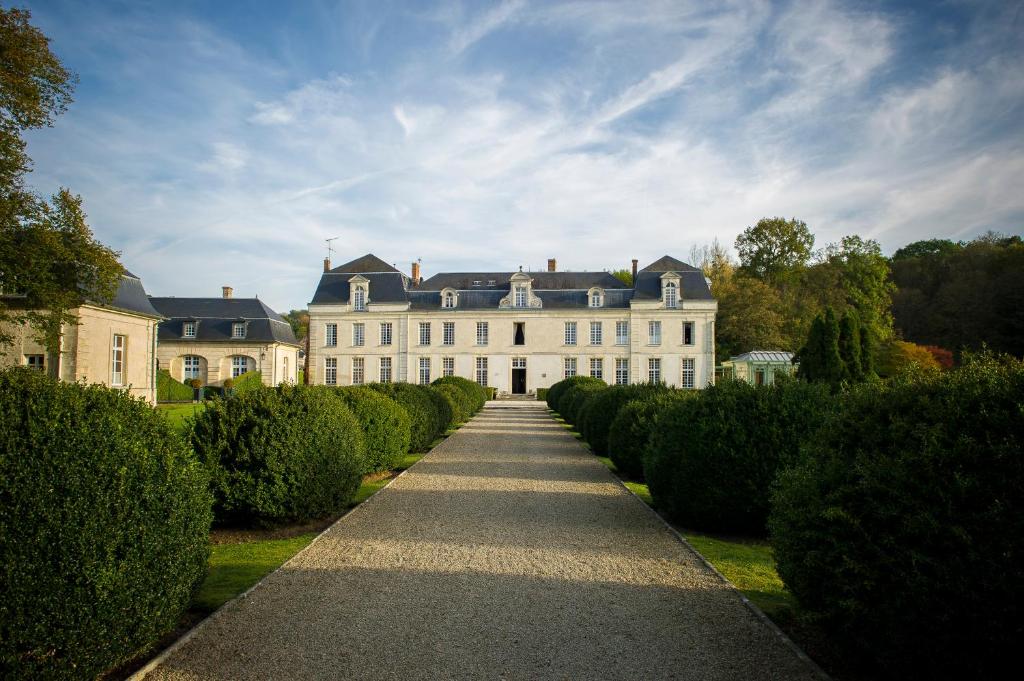 Courcelles-sur-Vesle科赛尔城堡酒店的一片大白色房子,一排灌木丛