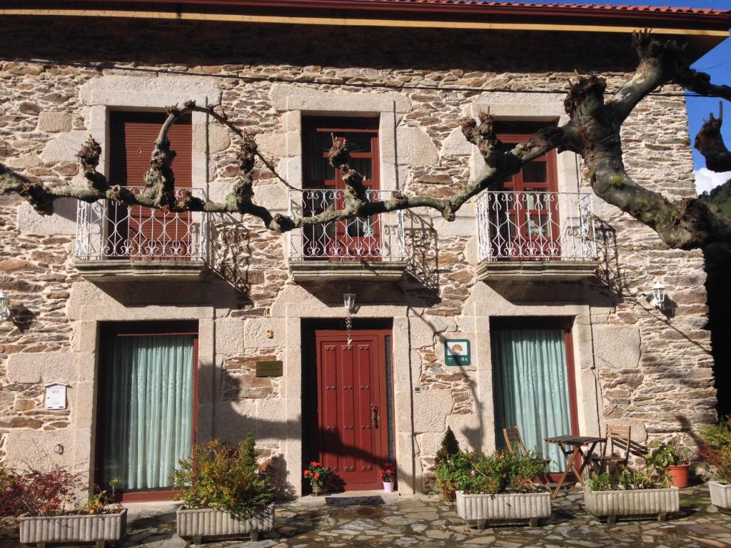Os PearesCasa Alpargateiro的一座石头建筑,设有红色的门和窗户