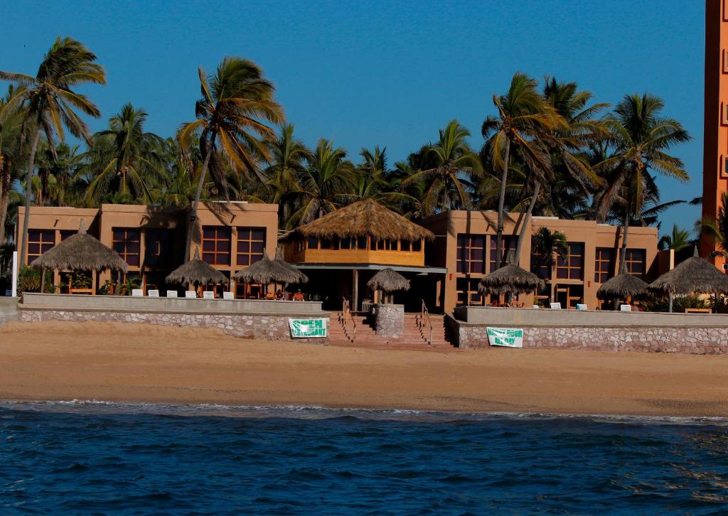 马萨特兰苍翠牧场别墅度假酒店的棕榈树和海洋海滩上的度假村