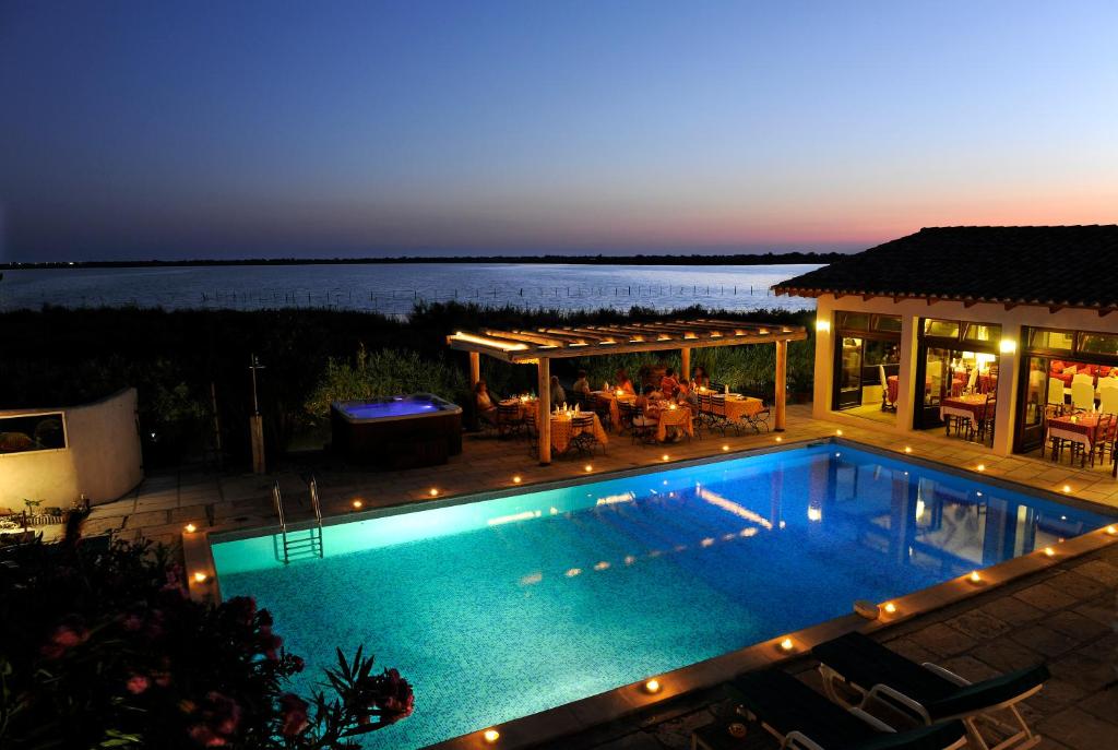 圣马迪拉莫Maison l'Etrier的夜间在房子前面的游泳池