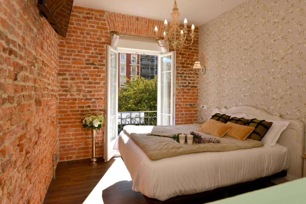 桑坦德Center Suite Santander的一间卧室设有一张床和砖墙