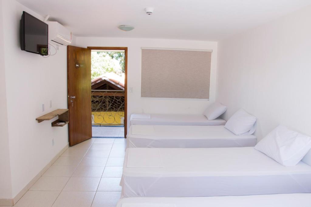 特林达迪Hotel Pousada Recanto do Pai的白色的客房配有两张床和电视。