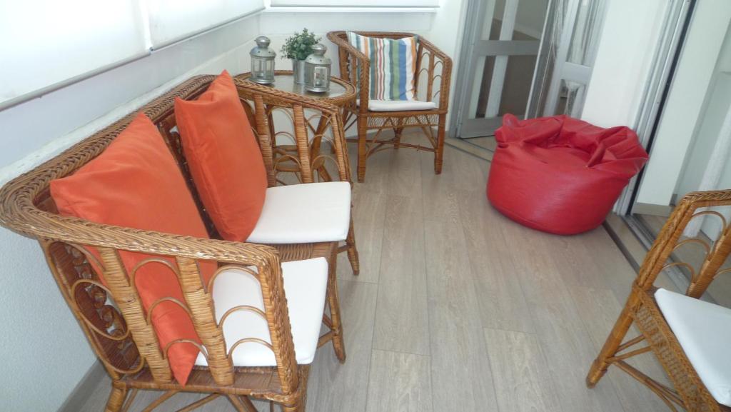 卡帕里卡海岸Casa Mar的一间设有椅子和一张桌子及红色袋子的房间