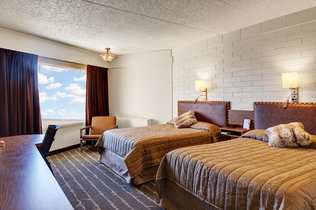 威利斯顿El Rancho Hotel的酒店客房设有两张床和窗户。