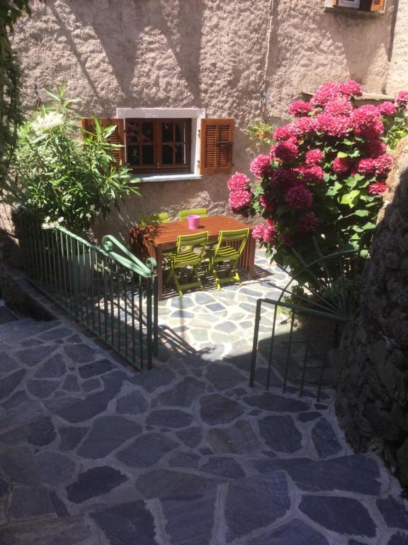 Castello-di-RostinoCasa a Stretta的庭院配有桌椅和鲜花