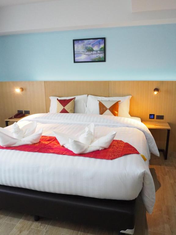 查汶苏梅岛城市酒店的卧室配有一张大白色床和红色毯子