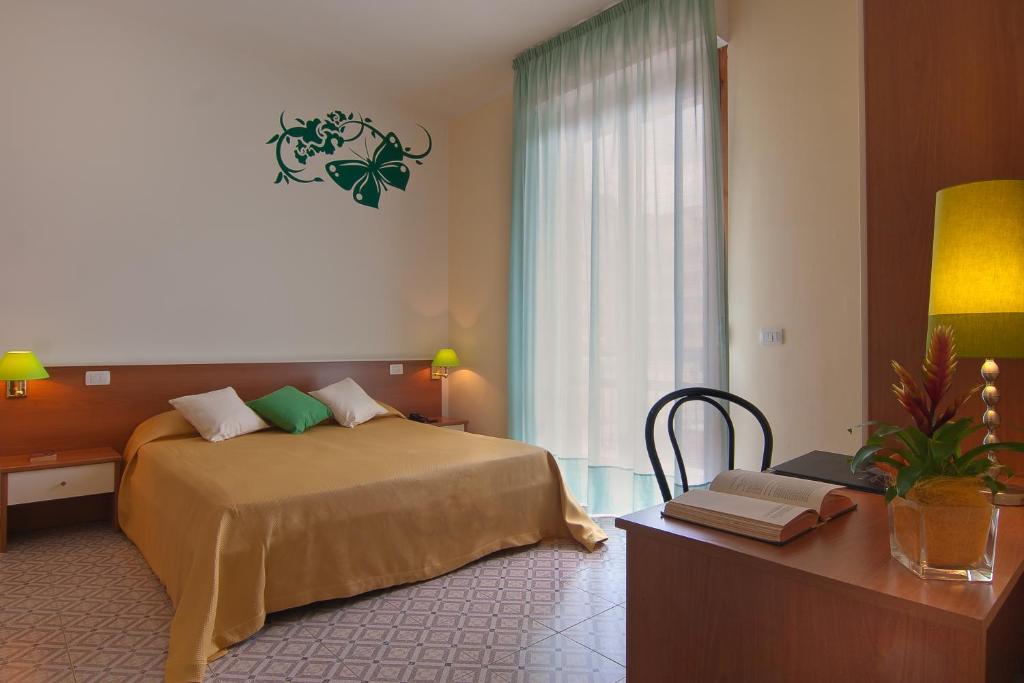 佛罗伦萨Mio Hotel Firenze的一间卧室配有一张床、一张书桌和一个窗户。