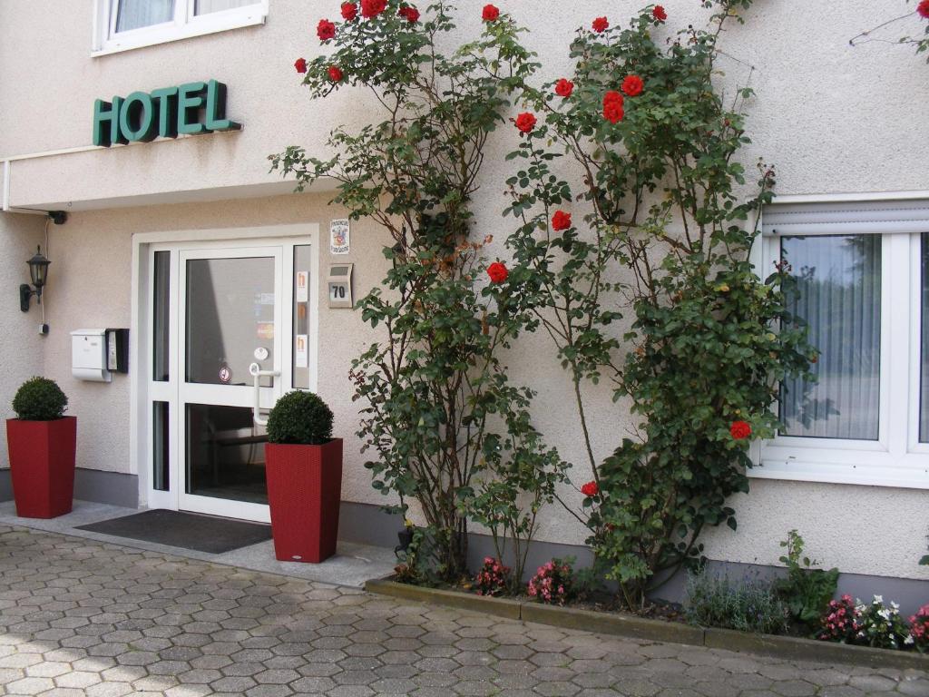 波鸿斯摩科特酒店的门前有红色花的建筑