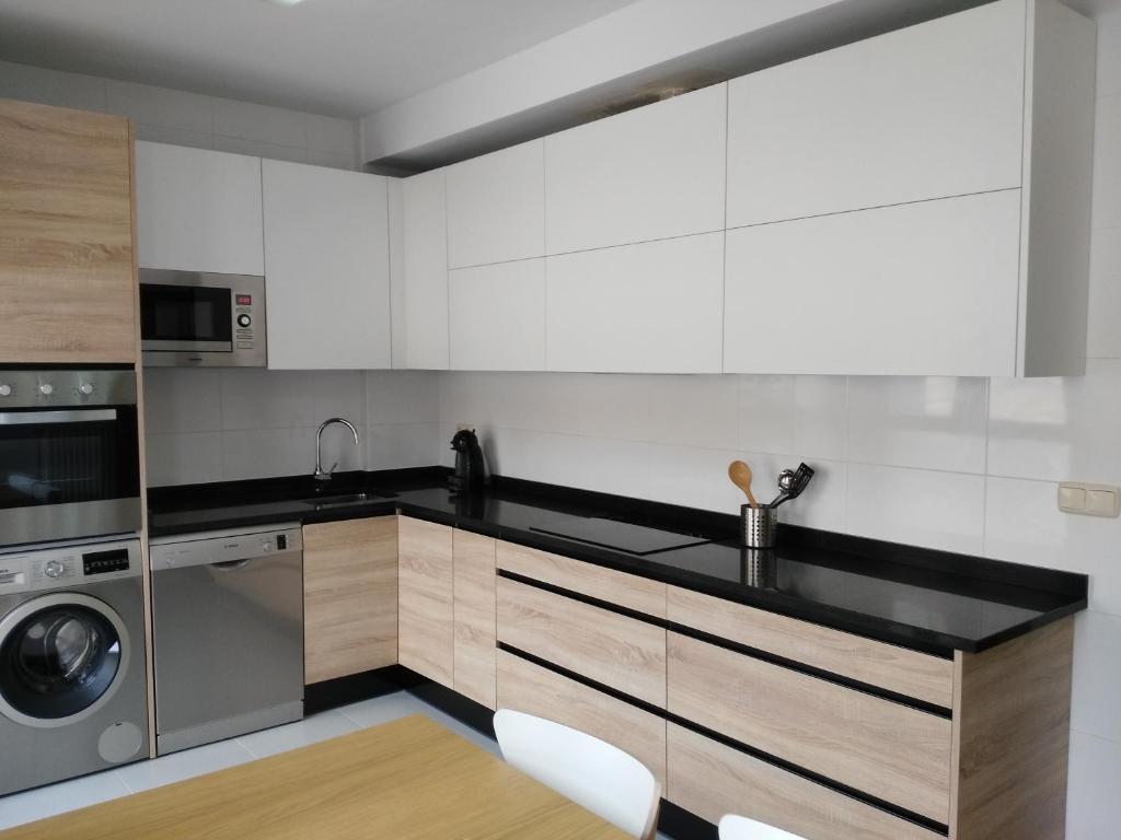 奥利特Apartamento turistico Olite的厨房配有白色橱柜、洗衣机和烘干机