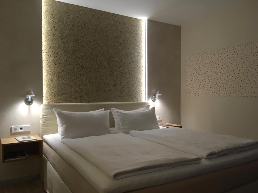 新勃兰登堡布朗达兰德酒店的卧室配有一张带白色床单和枕头的大床。