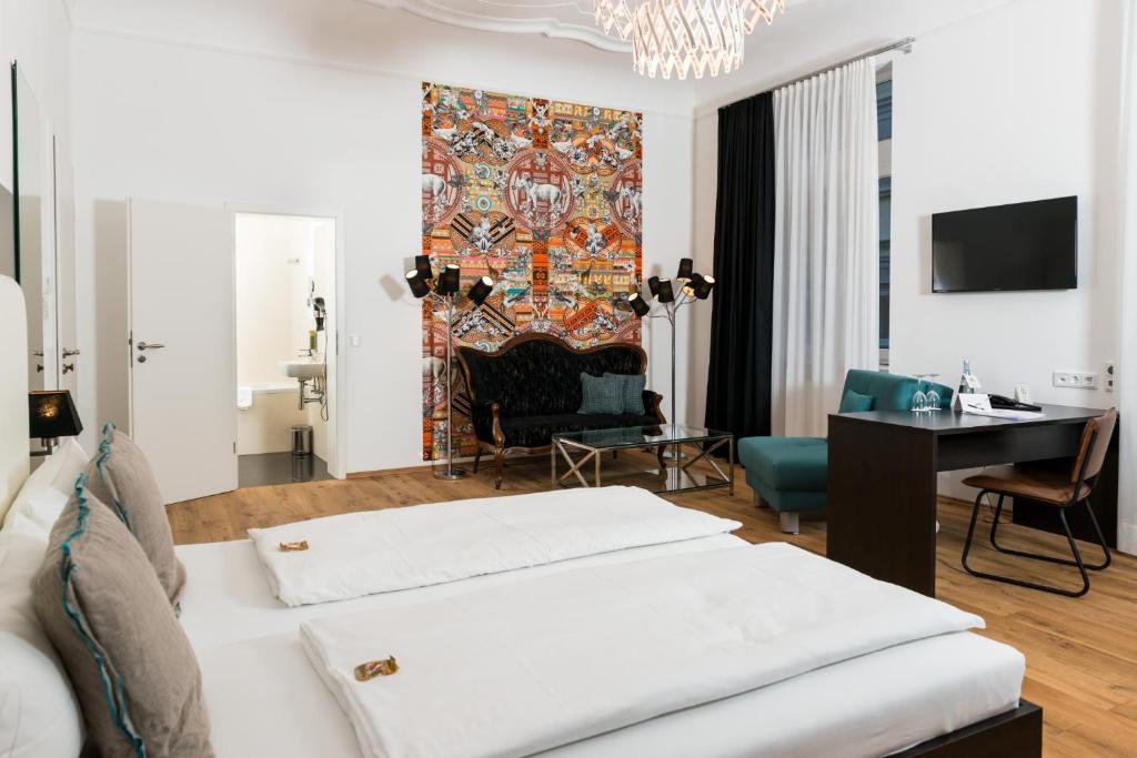 海德堡海德堡艾克泽冷兹酒店的酒店客房带两张床、一张桌子和一张沙发