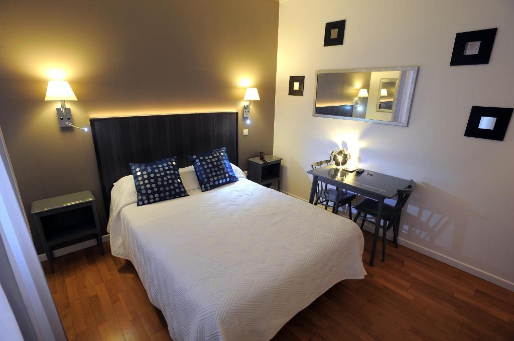 图尔意大利人酒店的一间卧室配有一张床、一张桌子和一面镜子